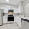 Renovated kitchen features quartz countertops and tile backsplash